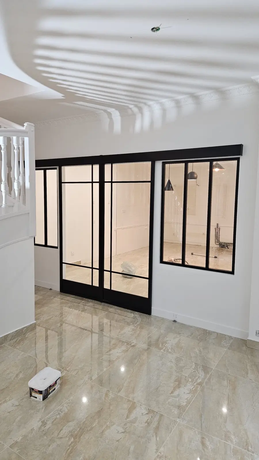 Entrée avec verrière et escalier blanc après rénovation